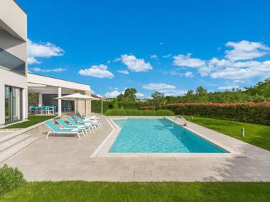 A modern luxury villa with a crystal-clear swimming pool and cultivated garden