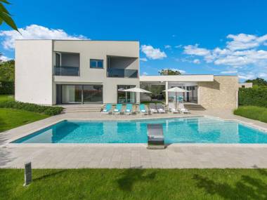 A modern luxury villa with a crystal-clear swimming pool and cultivated garden