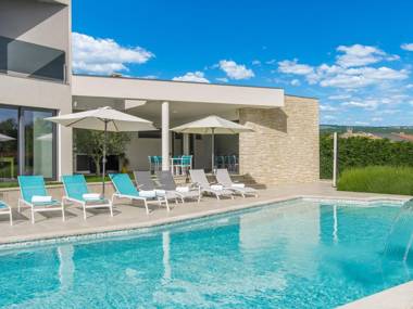 A modern luxury villa with a crystal-clear swimming pool and cultivated garden