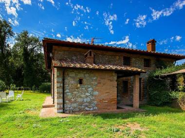 A rustic house set in the Tuscan landscape.