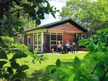 Nicely furnished bungalow with a fireplace and green area