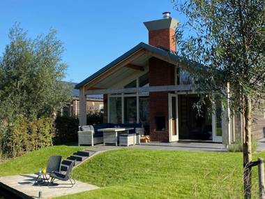 Modern bungalow with a fireplace located directly by water