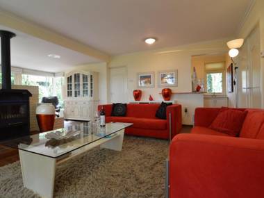 A detached bungalow with outdoor fireplace covered terrace and pond in a forest plot