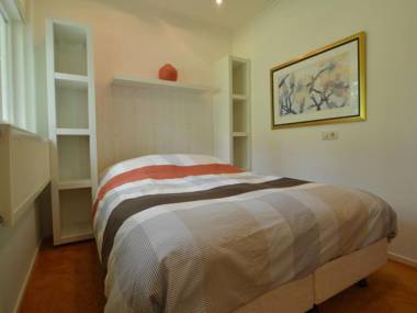 A detached bungalow with outdoor fireplace covered terrace and pond in a forest plot