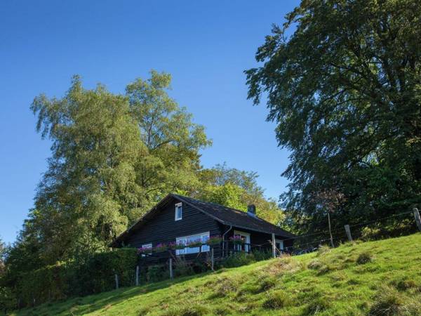 Open wooden chalet built against a hill.