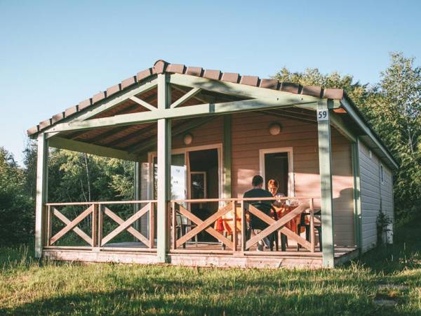 Wooden chalet with covered terrace on the edge of a lake