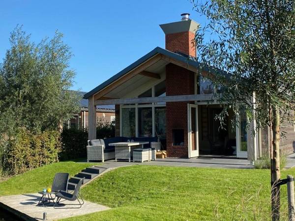 Modern bungalow with a fireplace located directly by water