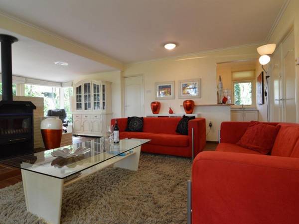 A detached bungalow with outdoor fireplace covered terrace and pond in a forest plot